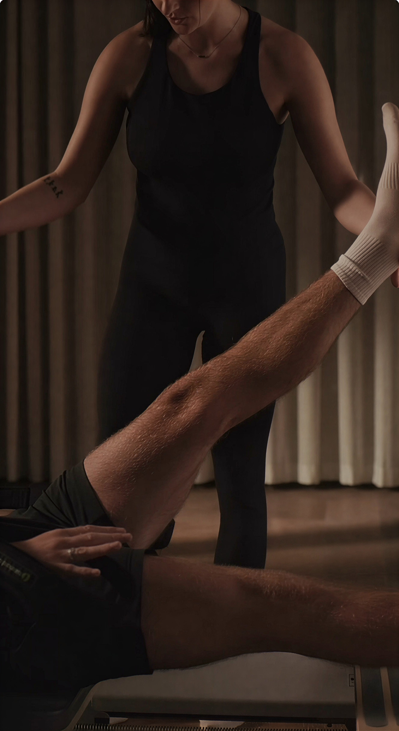 Pilates instructor practicing on a reformer in a sunlit studio at dawn
